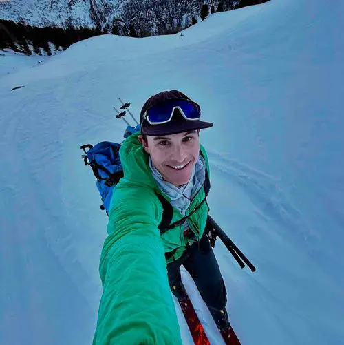 Skier in green jacket on snowy mountain