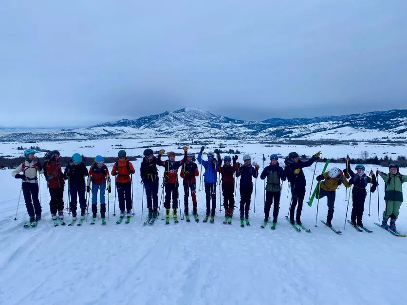 Skiers smiling on snowy mountain trail