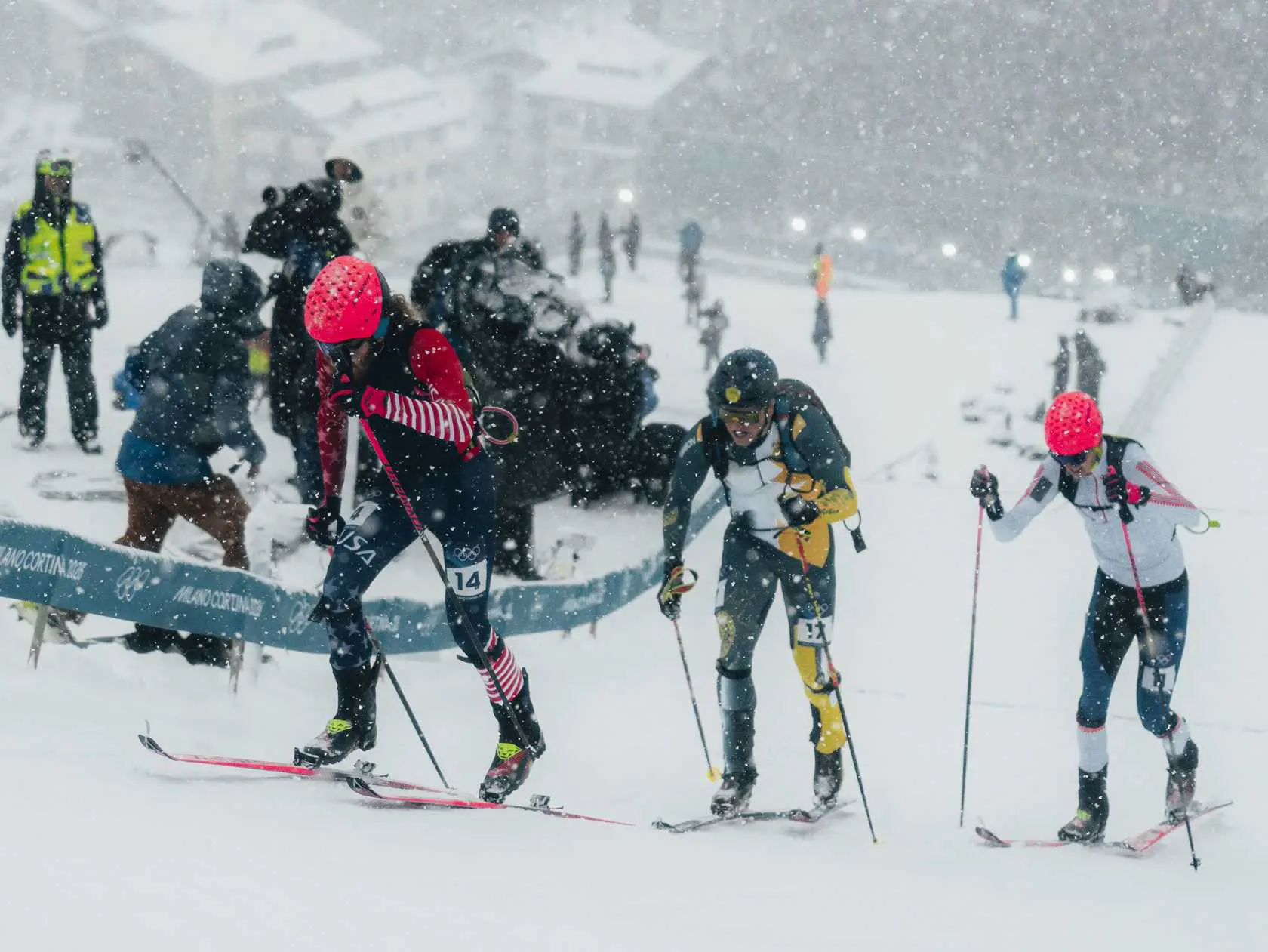 Athletes skiing uphill in a snowstorm