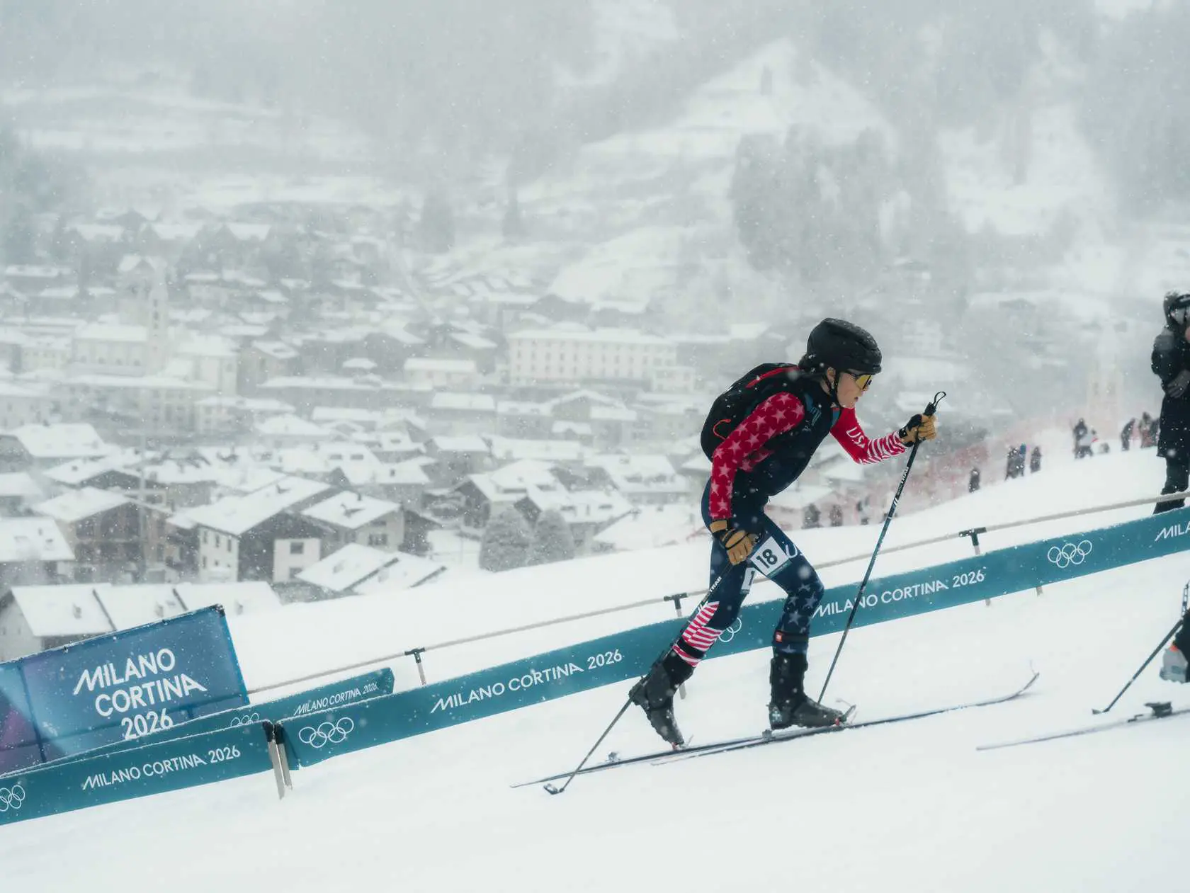 Skier in USA uniform ascending snowy mountain