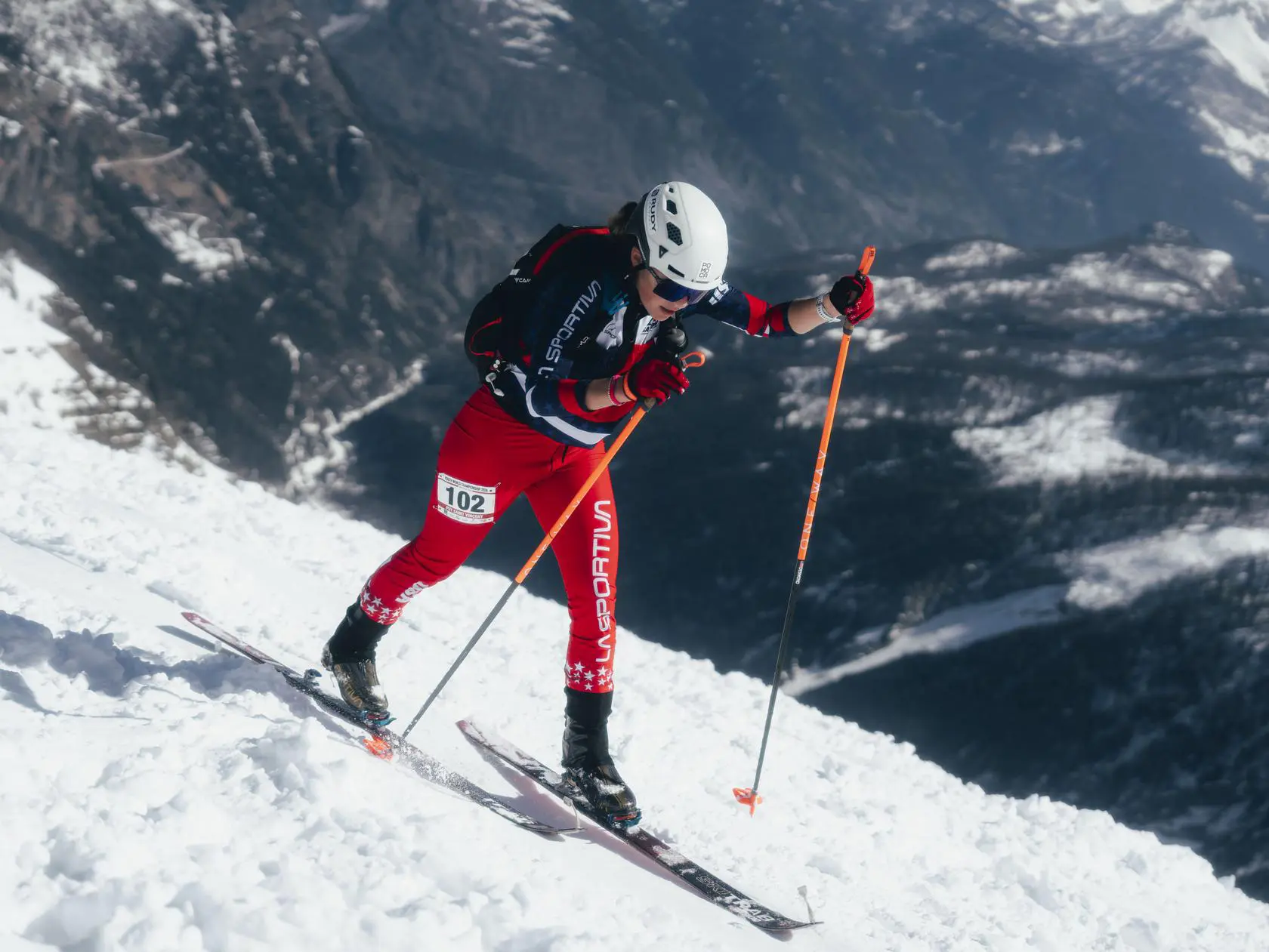 Skier in red suit climbing