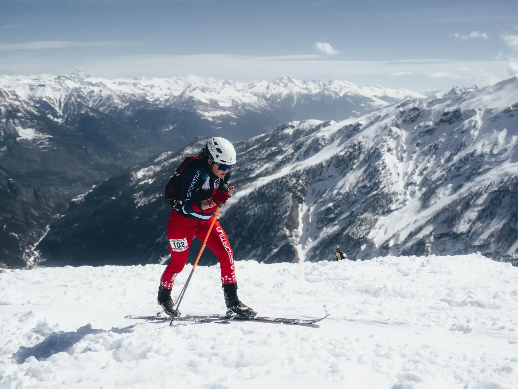 Skier ascending a snow-covered mountain peak