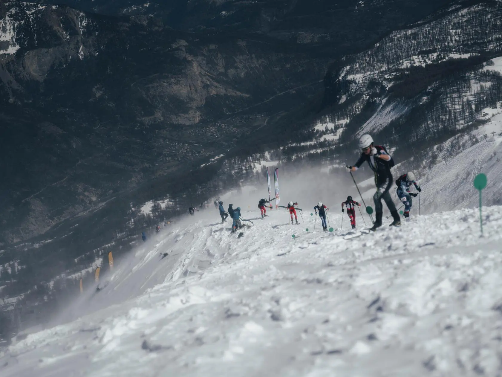 Skimo racers climbing snowy mountain slope