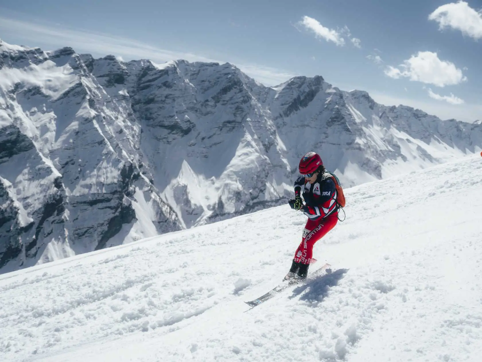 Skier on snow with mountains in background