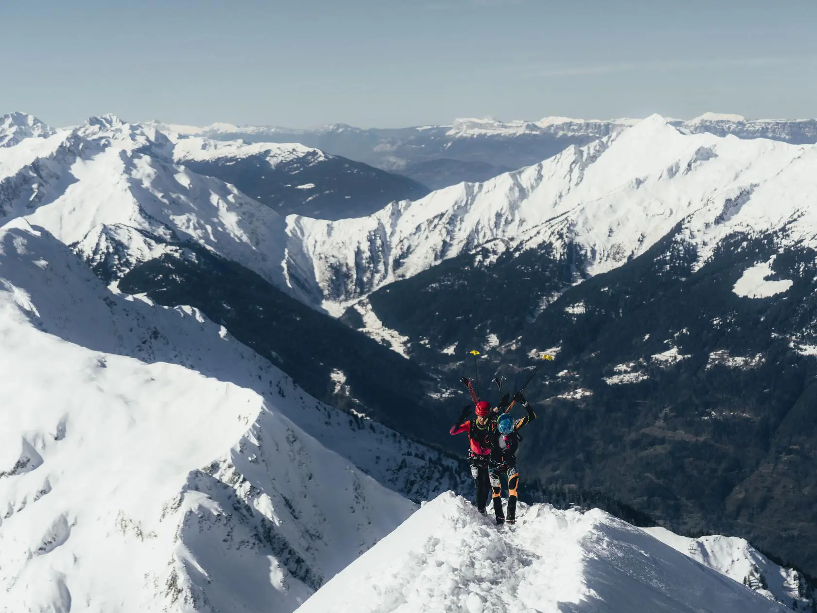 Two skiers hiking snowy mountain peak
