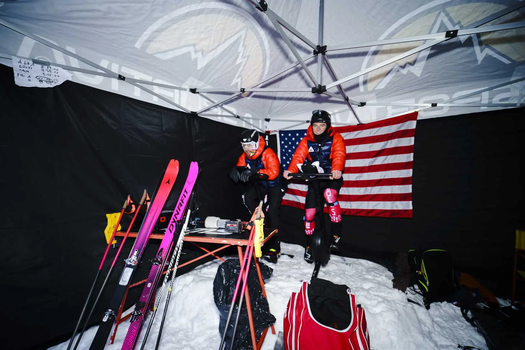 Skiers exercising under tent with American flag