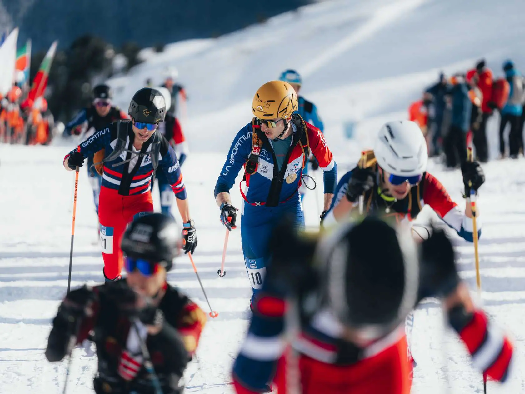 Ski mountaineering racers ascending snowy mountain.