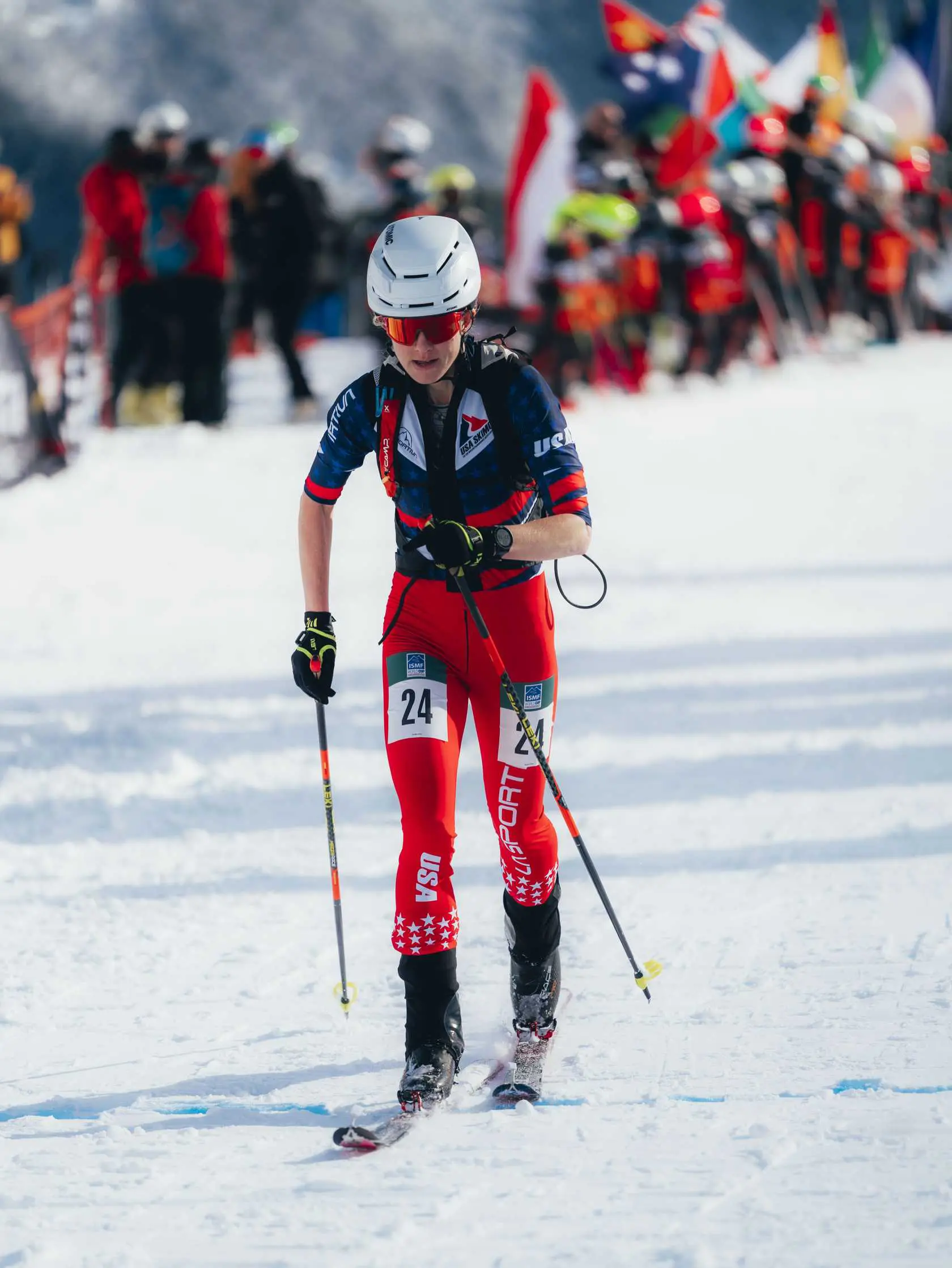 Skier #24 competing in snowy mountains