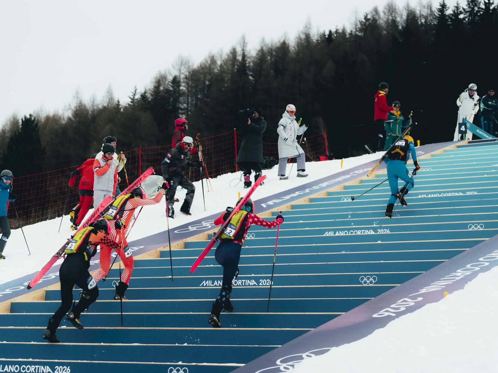 Ski mountaineers climb stairs with equipment