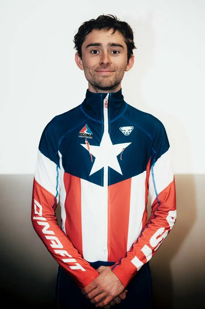 Man standing in front of a wall wearing a long-sleeved jersey with a star on it