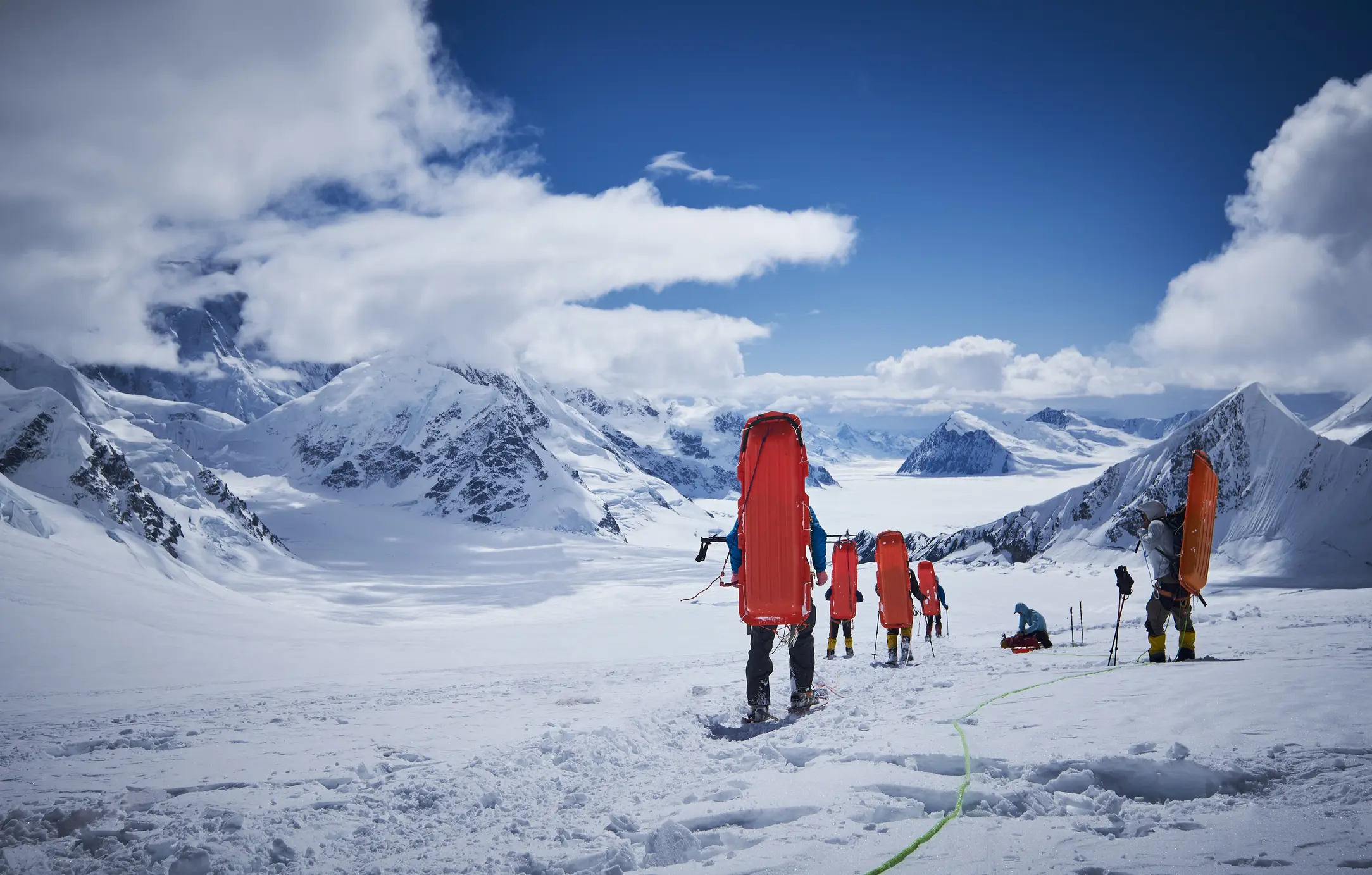 Mountaineers with sledge on his back coming down on Denali.