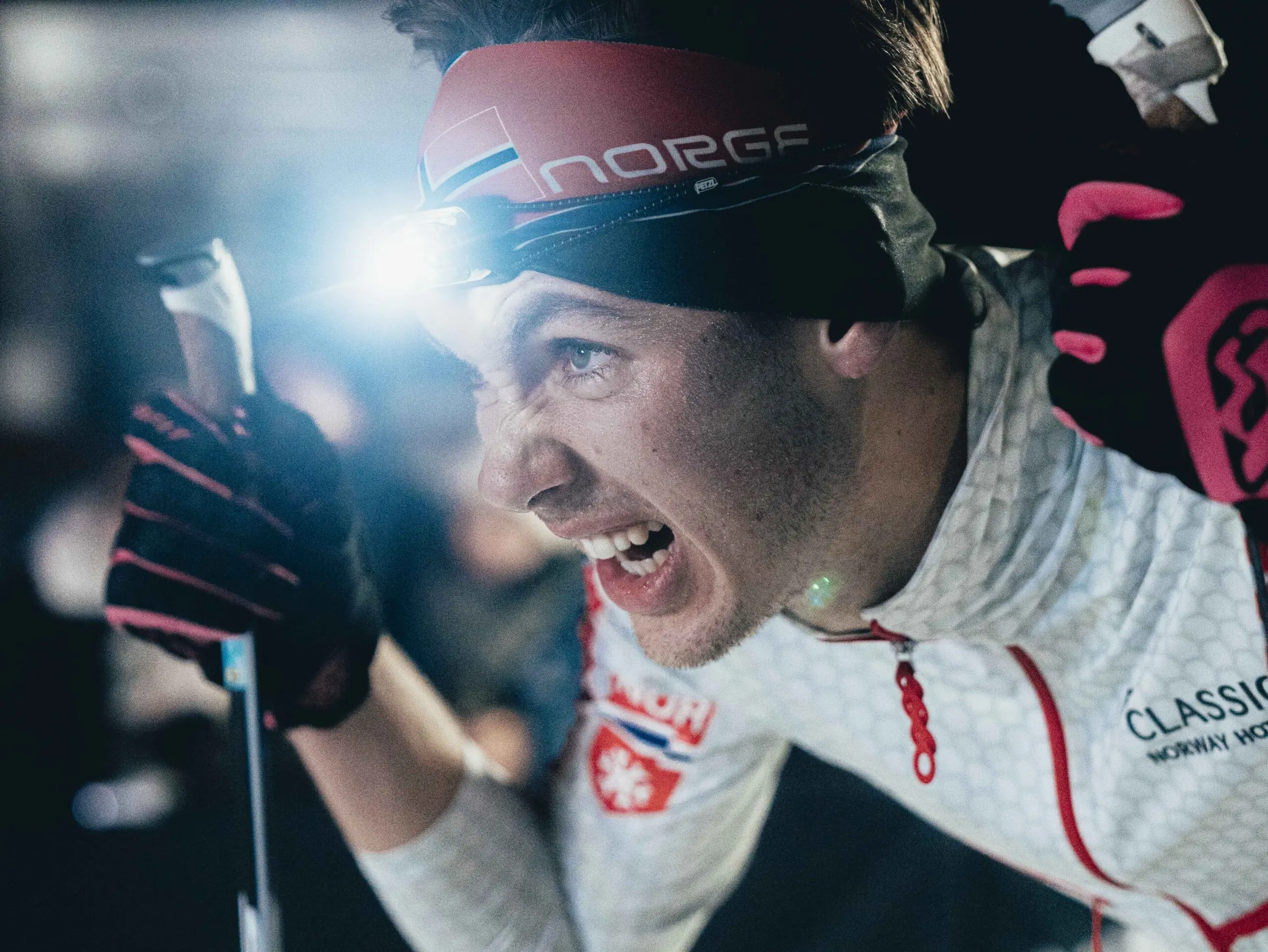 Intense male skier racing at night