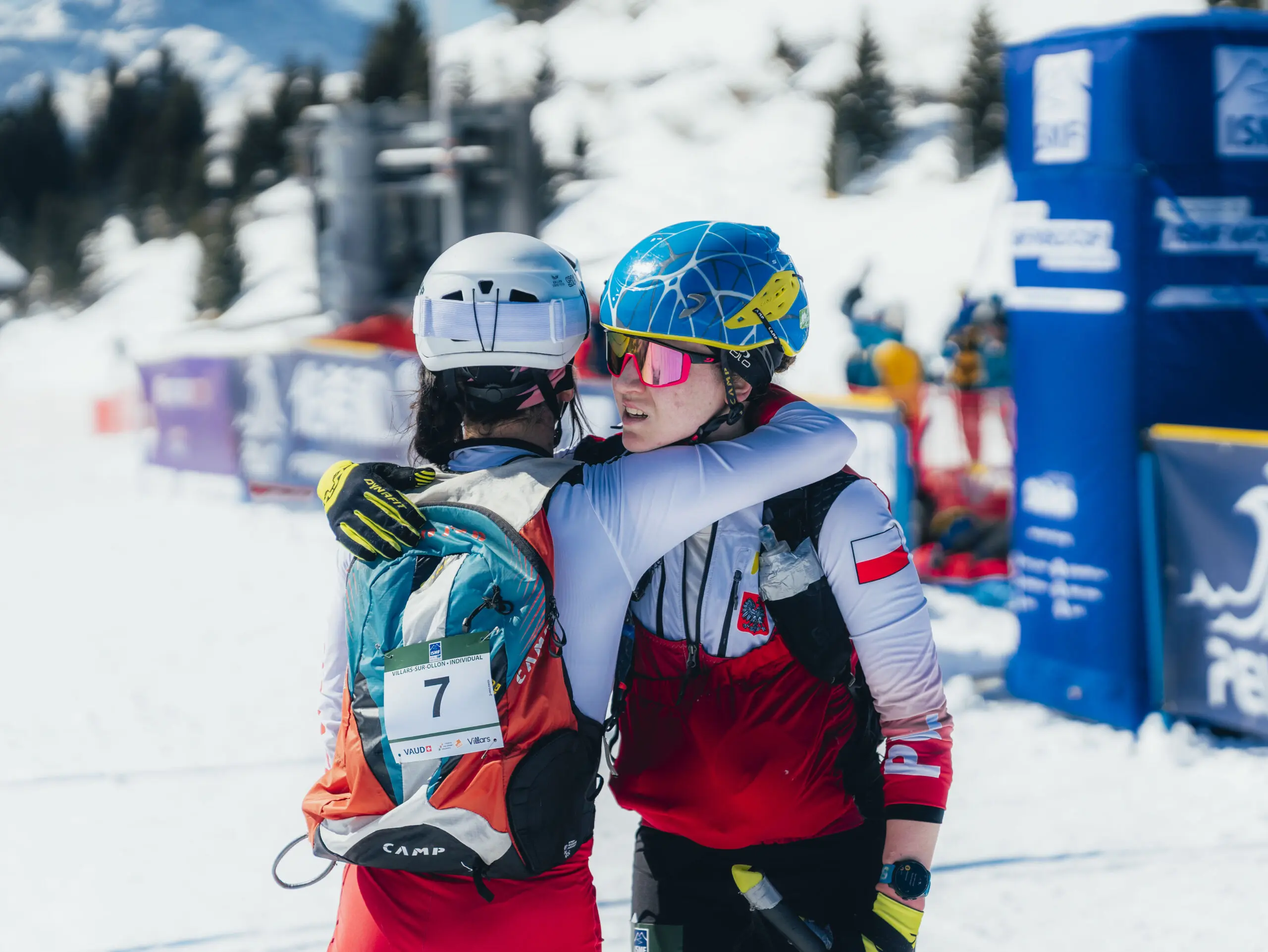 Two female athletes hug after ski race.