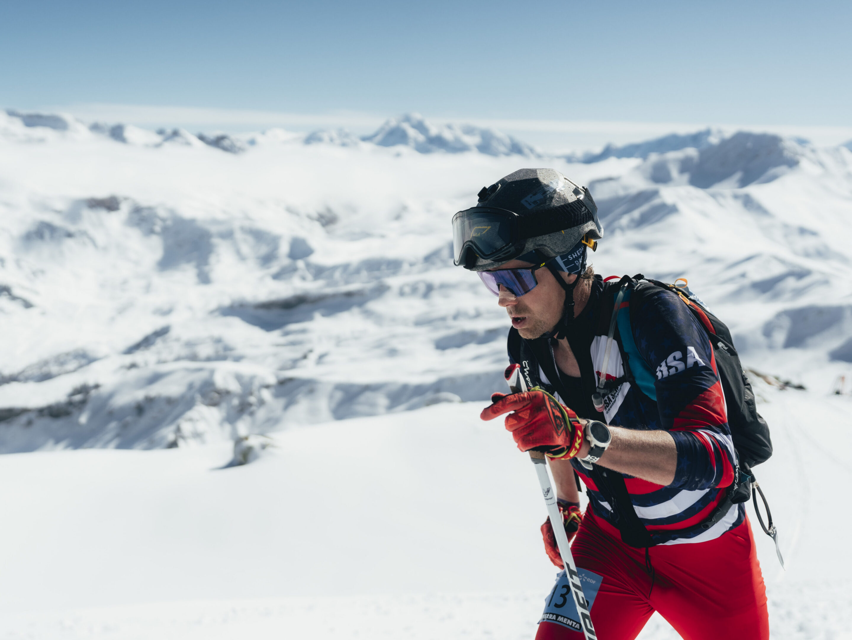 Man ski touring with backpack and poles