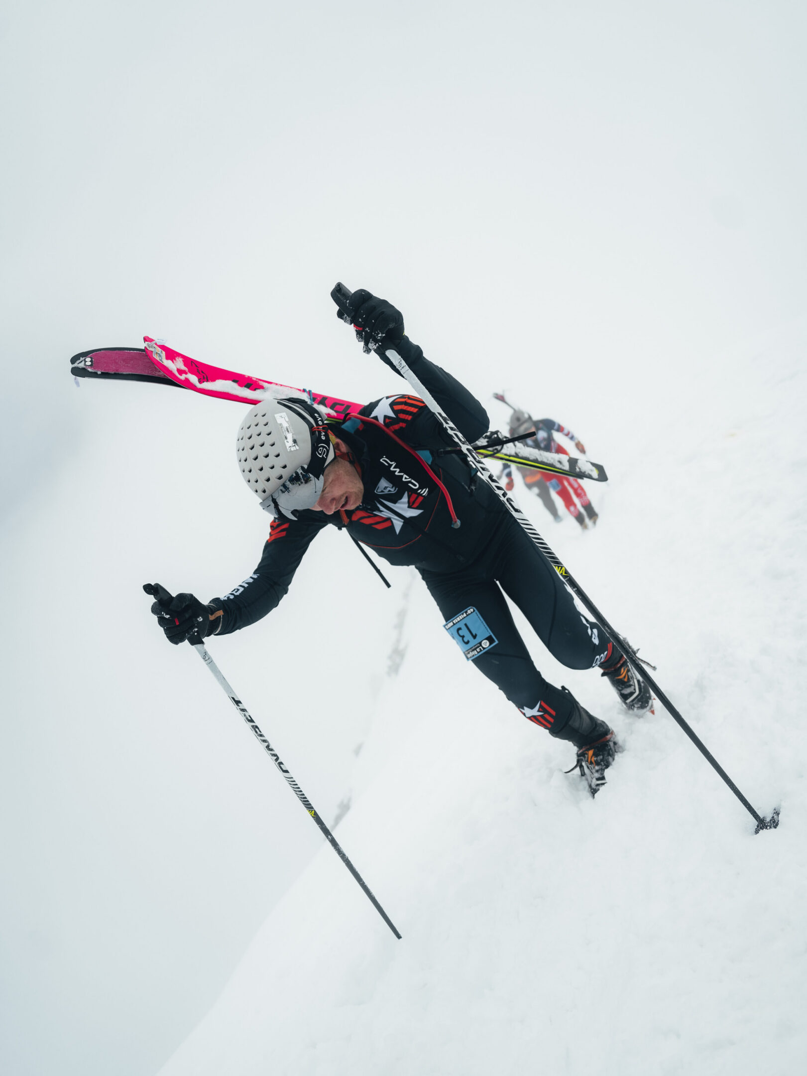 Skier ascending snowy mountain with skis