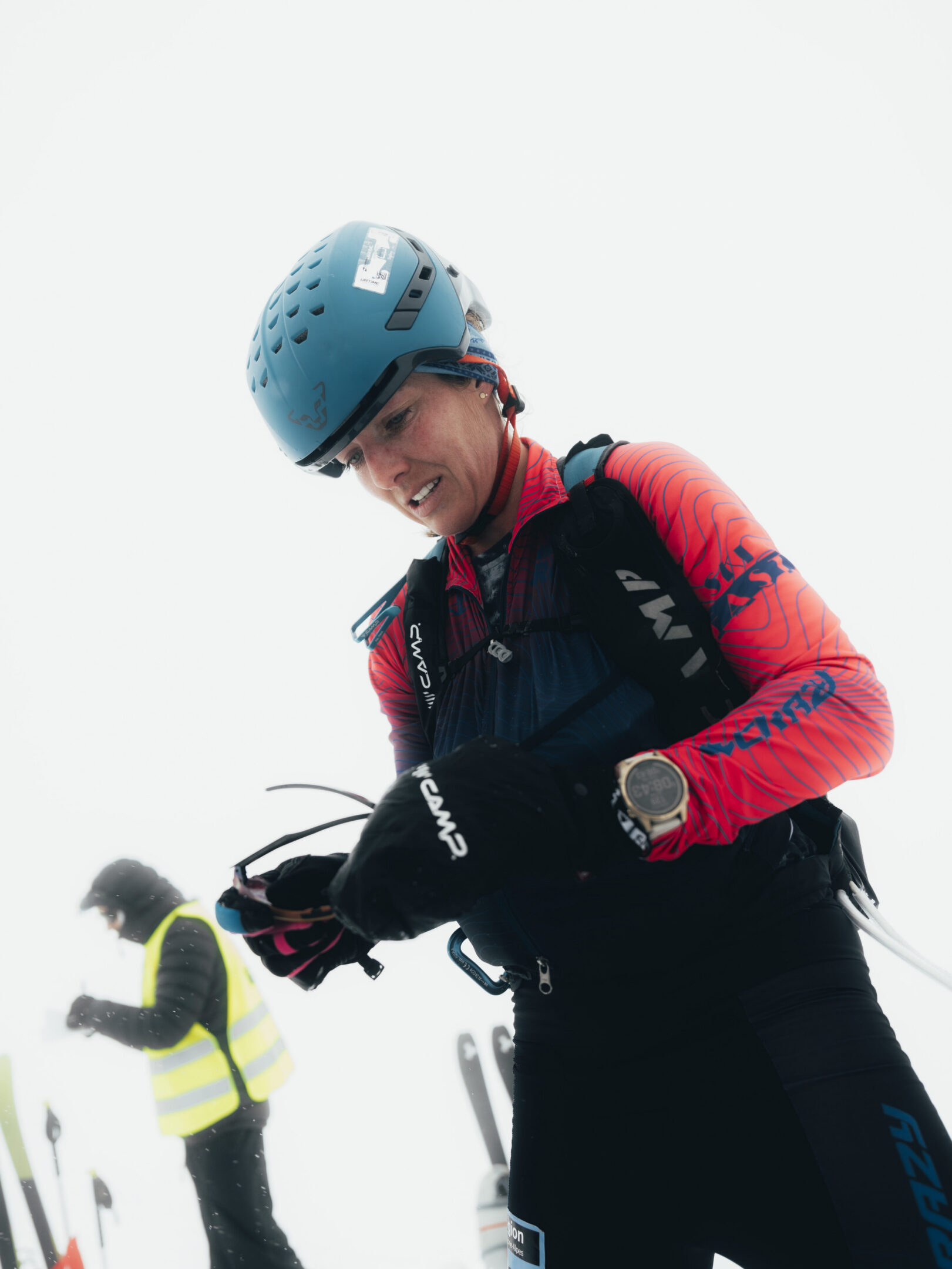 Skier in blue helmet adjusting gear