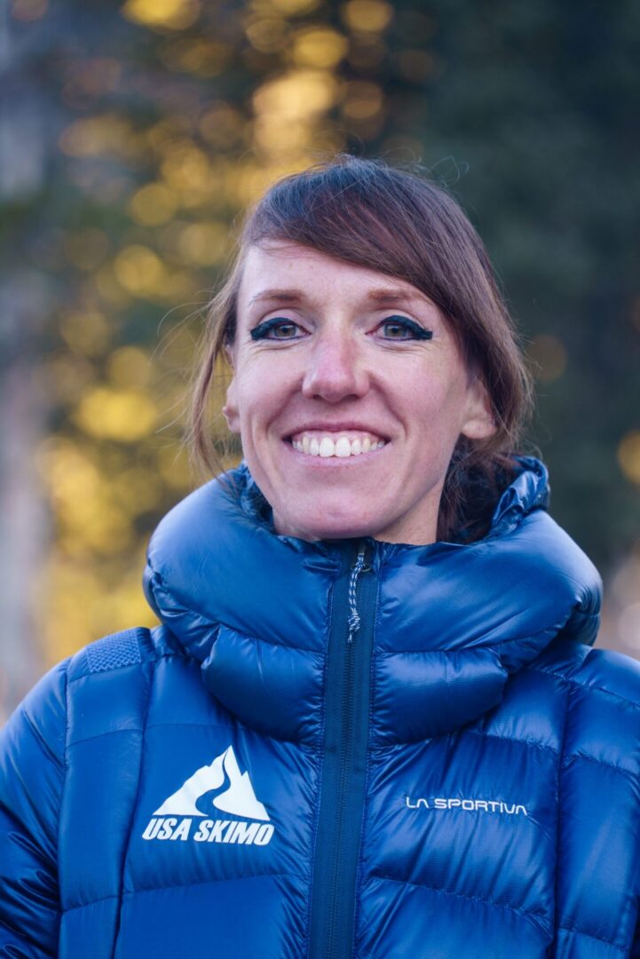 Woman in a jacket at the camera with a blurred background